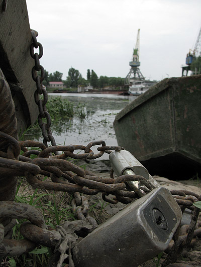 Замки з ланцюгами біля рибальських човнів в порті Чернігова