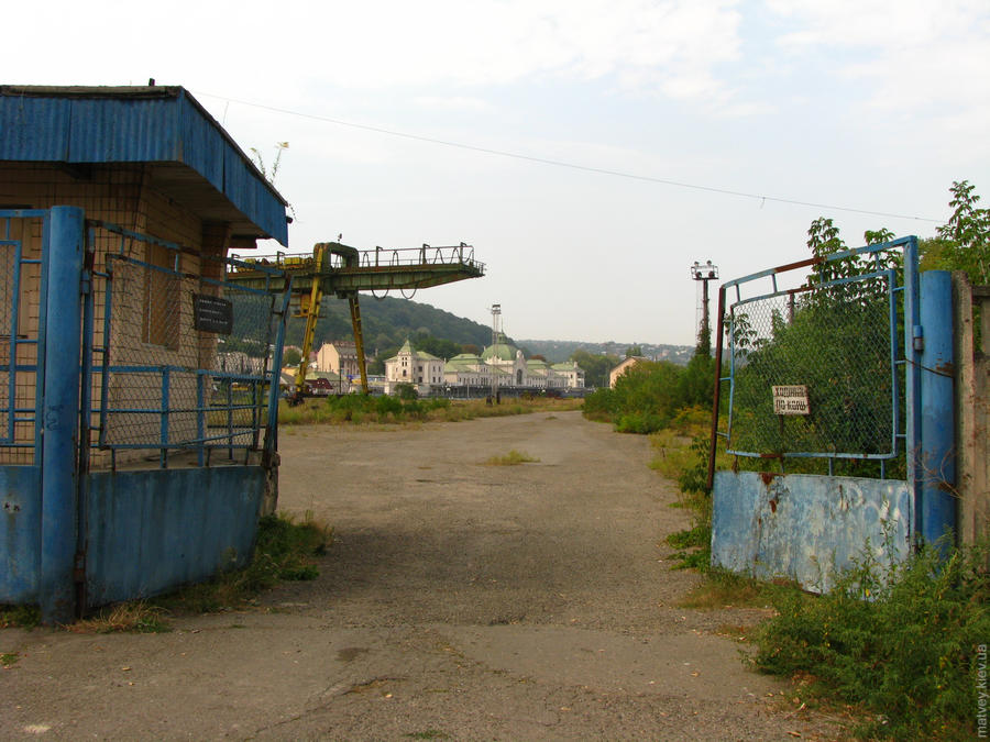 Вид на вокзал крізь іржаві ворота з боку промзони. Чернівці, Україна