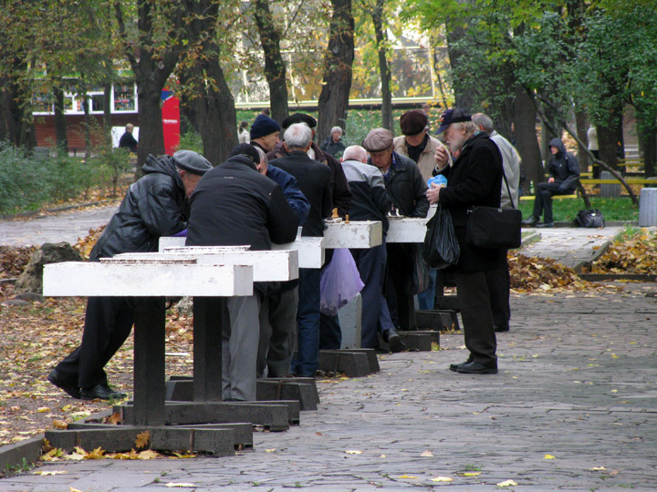 діди грають в шахи стоячи в парку Шевченко в Дніпрі