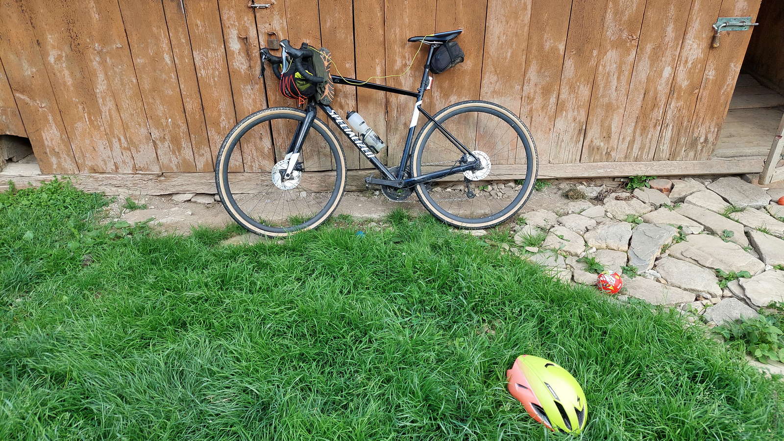 Чорний велосипед Specialized Diverge E5 Elite 2019 біля дерев'яної стіни та трави. Карпати, Україна