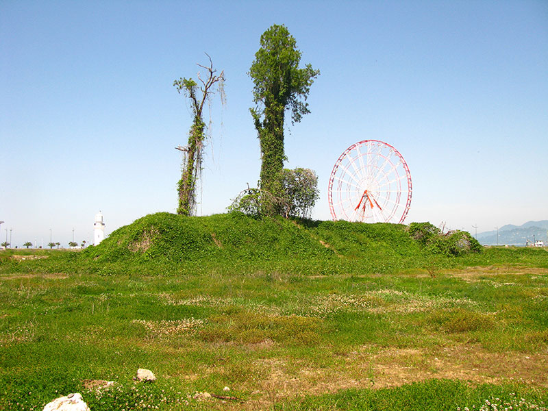Пустир з пагорбом та деревом біля ДНК Грузії, колеса огляду. Батумі