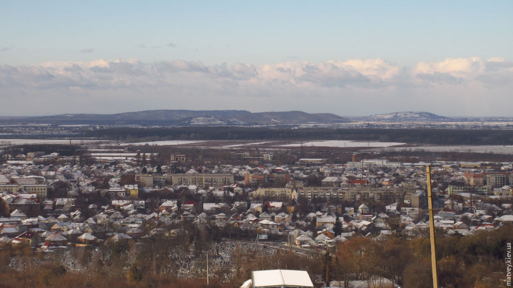 Зимний пейзаж с холмами и городом. Берегово