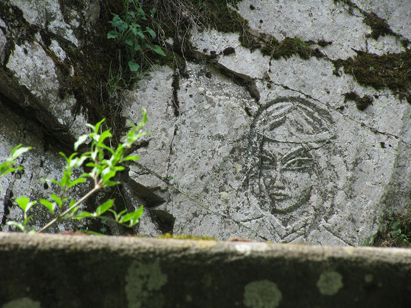 Женское лицо, нарисованное на скалистом берегу Боржомулы