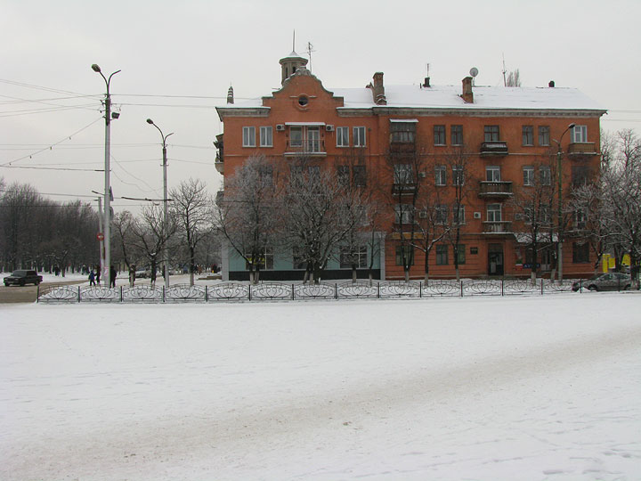 Старый красный четырехэтажный дом в Горловке зимой