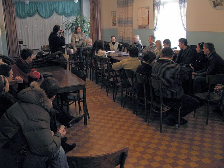 Творческий вечер Михайленко Елены в доме учителя в Горловке. Люди сидят за столами.