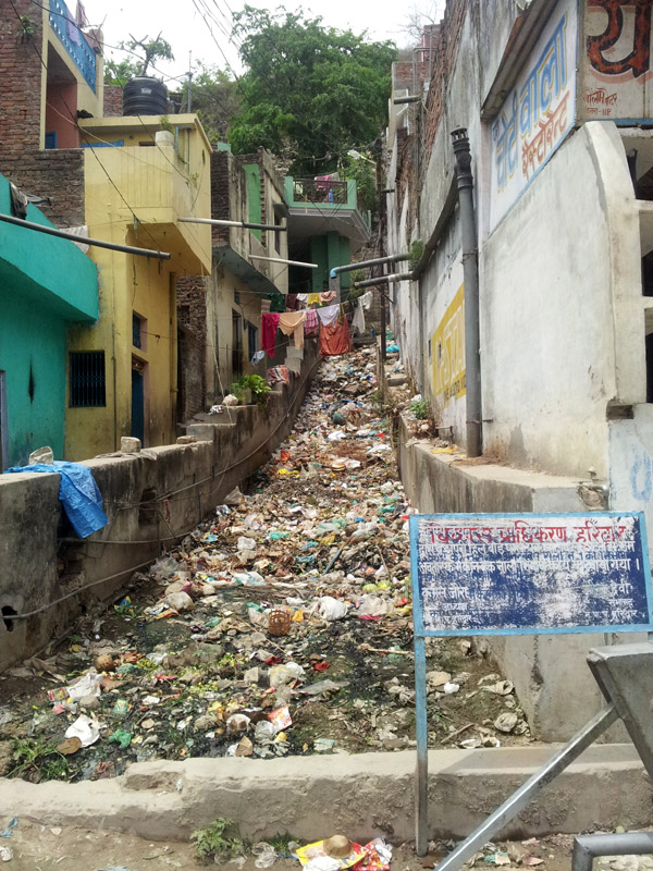 Ріка сміття між будинками у Харідварі, Індія.