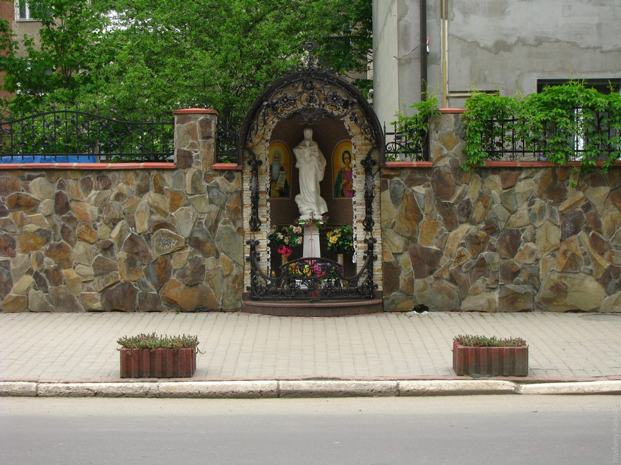 Статуя девы Марии в заборе