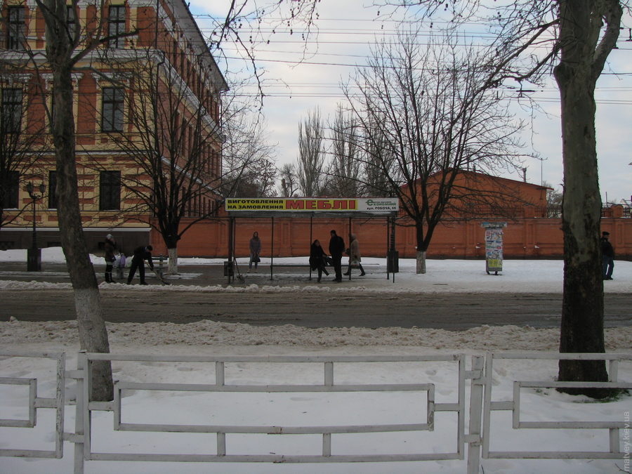 Автобусна зупинка з рекламою, але без назви. Зима. Херсон, Україна.