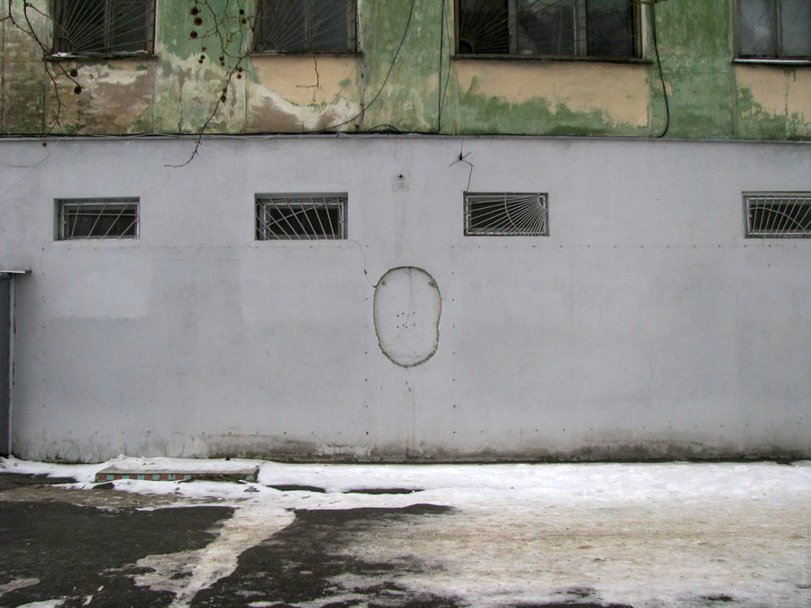 Слід на стіні, форма якого нагадує телефон-автомат. Зима. Херсон, Україна.