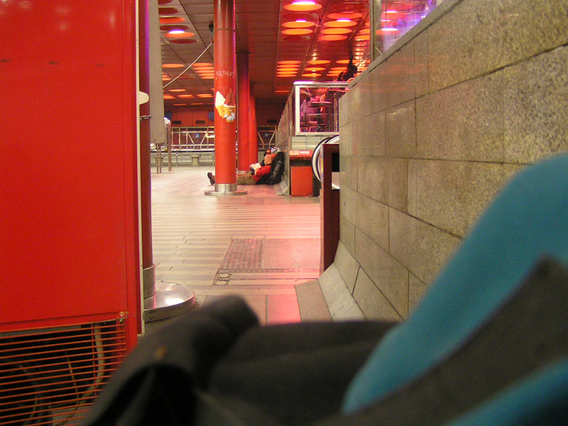 Турист с рюкзаком на полу зала жд-вокзала в Праге