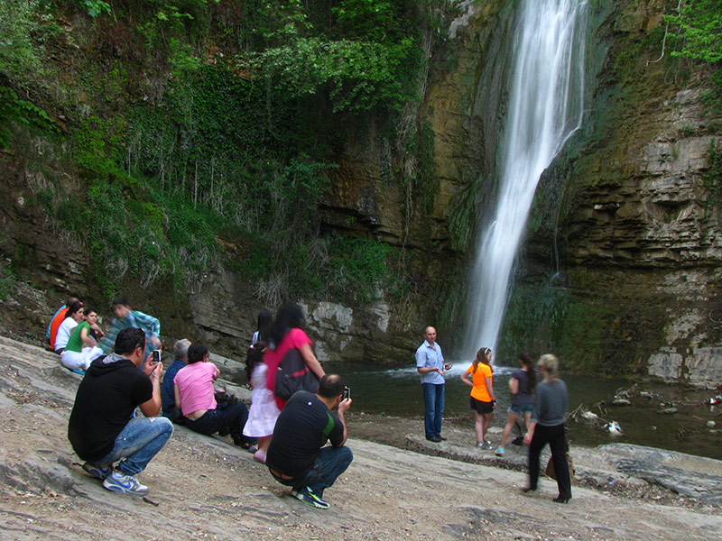 Туристы рядом с водопадом в ботсаду Тбилиси