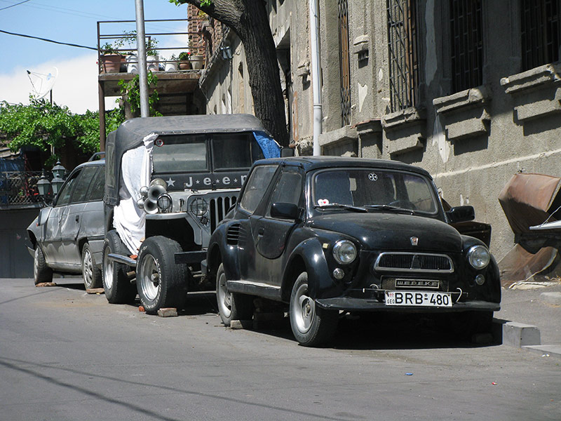 Старая маленькая машина с номером BRB-480 и шильдиком WEPEKE в Тбилиси